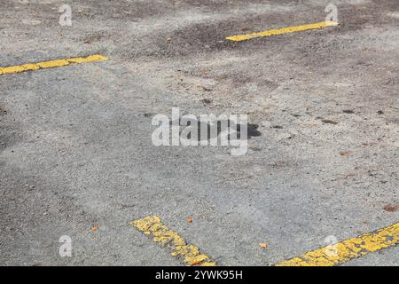 Ölflecken in Malaysia. Bodenverschmutzungsproblem. Ölflecken auf Asphaltflächen. Stockfoto