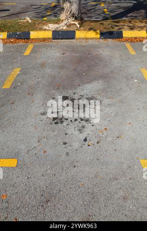 Ölflecken in Malaysia. Bodenverschmutzungsproblem. Ölflecken auf Asphaltflächen. Stockfoto
