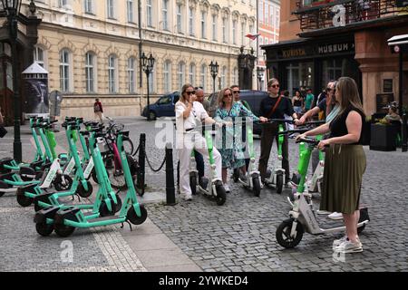 PRAG, TSCHECHISCHE REPUBLIK - 2. MAI 2024: Touristen fahren Lime Uber mietete Elektroroller in der Altstadt (Stare Mesto) von Prag, Tschechische Republik. Stockfoto
