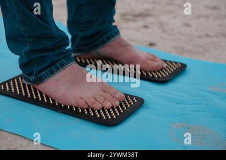 Männliche Füße stehen auf Sadhu Boards. Nahaufnahme. Das natürliche Bild eines Mannes Füße, die auf Nägeln stehen. Nagelstehend ist eine Heilpraxis für geistige und Phys Stockfoto
