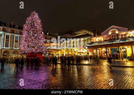 Leute, die nachts den beleuchteten Weihnachtsbaum vor dem Covent Garden Market fotografieren Stockfoto