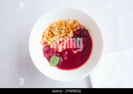 Eine frische Acai-Schüssel auf einer weißen Tischdecke - gesundes und stilvolles Frühstück. Stockfoto