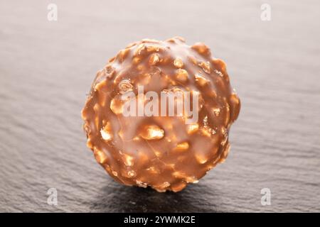Schokoladenbonbons mit Haselnüssen auf Schieferstein, Nahaufnahme. Stockfoto