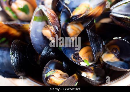 Gekochte Muscheln in Schüssel auf hölzernem Hintergrund aus nächster Nähe Stockfoto