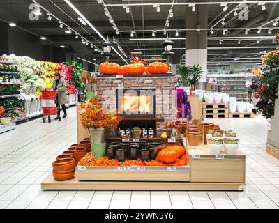 Moskau, Russland, September 2020: Halloween und Thanksgiving Dekoration im Laden. Kamin, Kürbisse, Herbstblätter. Käufer mit einem Hopping-Cart. Stockfoto