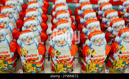 Moskau, Russland, November 2020: Viele Schokoladen-Weihnachtsklauseln von Kinder im knalligen orange-roten Outfit mit Logo. Stockfoto