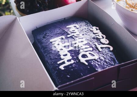 Lilafarbener Yamskuchen mit Schriftzug „Happy Birthday Jesus“ auf der Party zum frohen Weihnachtsfeiertag. Selektiver Fokus. Isoliert. Nahaufnahme. Stockfoto