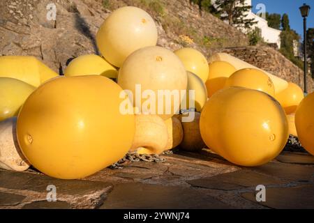 Gelbe Bojen liegen am Hafenpier von Portlligat in der Morgensonne, Cadaqués, Katalonien, Spanien Stockfoto