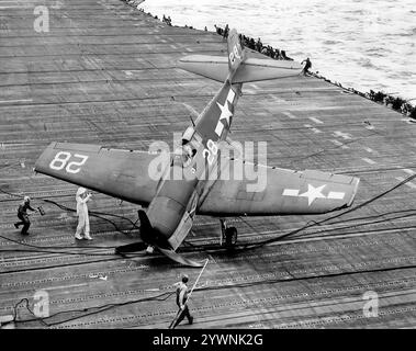 Ein umkämpfter Grumman F6F Hellcat auf dem Flugdeck der USS Hornet während der Schlacht an der Philippinischen See im Juni 1944. Das amerikanische Trägerflugzeug des Zweiten Weltkriegs feierte sein Kampfdebüt im September 1943 und etablierte sich anschließend als robuster, gut konstruierter Trägerflugzeug. In der zweiten Hälfte des Pazifikkrieges wurde sie zum dominierenden Jagdflugzeug der United States Navy. Insgesamt wurden 12.275 in etwas mehr als zwei Jahren gebaut und Hellcats wurde zugeschrieben, während sie im Dienst waren, insgesamt 5.223 feindliche Flugzeuge zu zerstören. Stockfoto