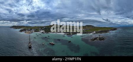 Aus der Vogelperspektive auf das klare blaue Meer und die Häuser der schottischen Insel Iona Schottland Großbritannien Innere Hebriden vor der Isle of Mull Westküste Schottlands ein beliebtes Ziel Stockfoto