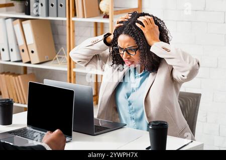 Gestresste junge Frau, die Fehler findet, Überstunden oder fehlende Frist im Büro arbeitet Stockfoto