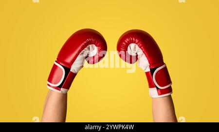 Unkenntlich Kämpfer zeigt Hände im Boxhandschuh auf orangefarbenem Hintergrund, Nahaufnahme. Panorama Stockfoto