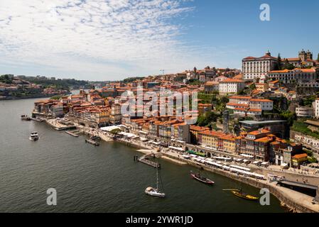 Ein Panoramablick auf das historische Viertel Ribeira in Porto, Portugal, mit farbenfrohen Gebäuden am Wasser, dem Fluss Douro und traditionellen Booten. Stockfoto