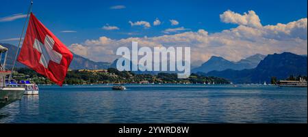 Panoramablick auf den Vierwaldstättersee mit der Schweizer Flagge vor dem Hintergrund des majestätischen Pilatus und Rigi in den Schweizer Alpen, Luzern, Schweiz Stockfoto