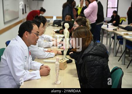 Msida, Malta. Dezember 2024. Mitglieder des 20. Chinesischen medizinischen Teams für Malta bieten am 11. Dezember 2024 kostenlose Gesundheitsberatungen und klinische Dienstleistungen für Studenten an der Universität von Malta in Msida, Malta. Maltesische Studenten haben diese Woche die traditionelle chinesische Medizin (TCM) und die chinesische Sprache in einem einzigartigen kulturellen Erlebnis entdeckt, das vom Konfuzius-Institut an der Universität Malta organisiert wird. Quelle: Jonathan Borg/Xinhua/Alamy Live News Stockfoto