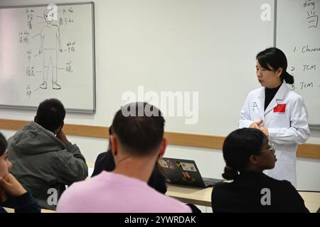 Msida, Malta. Dezember 2024. Tang Limei (Rear), Mitglied des 20. Chinesischen medizinischen Teams für Malta, hält am 11. Dezember 2024 einen Vortrag über traditionelle chinesische Medizin an der Universität von Malta in Msida, Malta. Maltesische Studenten haben diese Woche die traditionelle chinesische Medizin (TCM) und die chinesische Sprache in einem einzigartigen kulturellen Erlebnis entdeckt, das vom Konfuzius-Institut an der Universität Malta organisiert wird. Quelle: Jonathan Borg/Xinhua/Alamy Live News Stockfoto