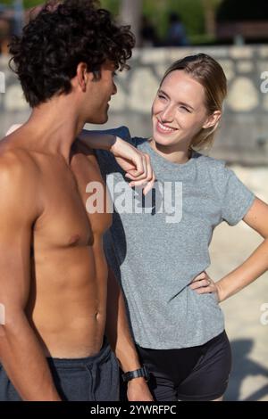 Ein junges, fittes Paar posiert am Strand Stockfoto