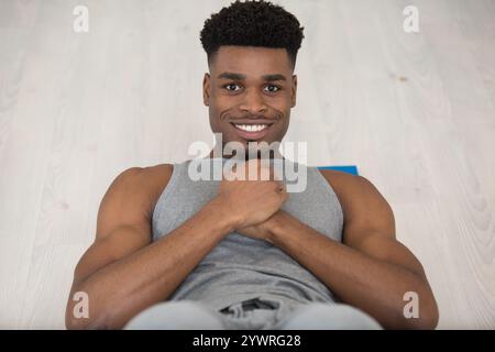 Muskulöser Mann, der Sit-ups macht Stockfoto