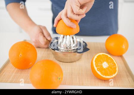 Zugeschnittene Ansicht der Hand, die Orange für Saft drückt Stockfoto