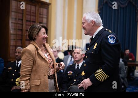 Washington, Usa. Dezember 2024. Der Polizeichef J. Thomas Manger spricht mit dem Vorsitzenden der US-Senatorin Amy Klobuchar, D-MN, bevor er am Mittwoch, den 11. Dezember 2024, bei einer Anhörung zu Regeln und Verwaltung des Senats im Bürogebäude des Russell Senats in Washington, DC, aussagte. Foto: Annabelle Gordon/UPI. Quelle: UPI/Alamy Live News Stockfoto