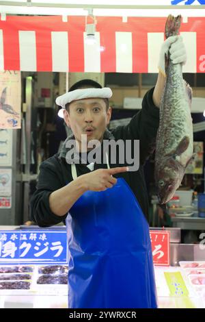 Männlicher Angestellter im Frischfischgeschäft mit Fisch Stockfoto