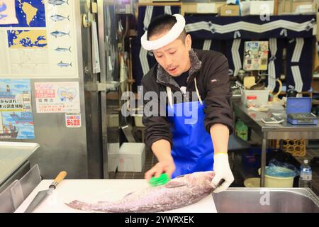 Männlicher Angestellter im Frischfischgeschäft, der Fischwaagen nimmt Stockfoto