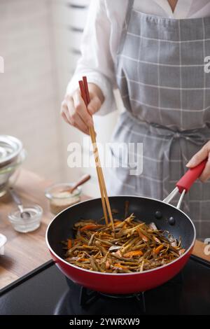 Frau, die den Kinpira-Gobo beendet Stockfoto