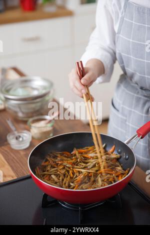 Frau, die den Kinpira-Gobo beendet Stockfoto