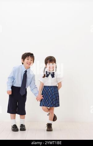 Halb Jungen und Mädchen in Schuluniform Stockfoto