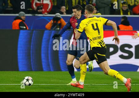 Dortmund, Deutschland. Dezember 2024. Nico Schlotterbeck (R) von Borussia Dortmund streitet mit Robert Lewandowski aus Barcelona während des UEFA Champions League-Spiels zwischen Borussia Dortmund und FC Barcelona am 11. Dezember 2024 in Dortmund. Quelle: Joachim Bywaletz/Xinhua/Alamy Live News Stockfoto