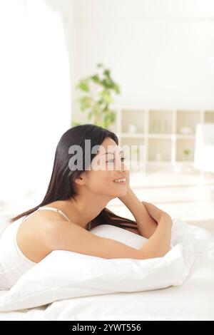 Junge Frau im Bett entspannen Stockfoto