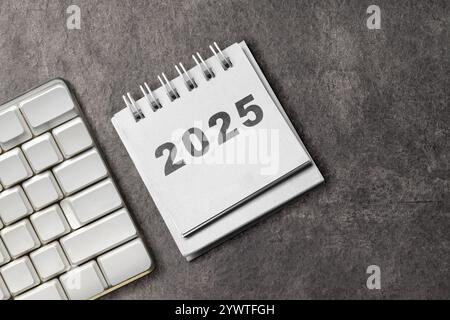 Kalender oder Notizblock mit der Zahl 2025 auf schwarzem Hintergrund. Happy New Year Concept oder Celebration Stockfoto