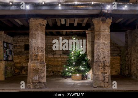 Weihnachtsbaum bei Nacht mit Dekoration im Tolsey Museum. Burford, Cotswolds, Oxfordshire, England Stockfoto