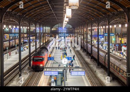 Überfüllter Hauptbahnhof Basel SBB in der Schweiz mit zwei Zügen am Abend Stockfoto