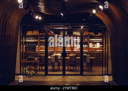 Weinraum im Ladenkeller. Flaschen mit verschiedenen Weinen liegen wunderschön auf der Theke. Stockfoto