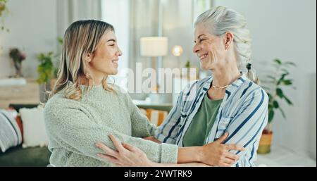 Familie, Liebe und Seniorin mit Frau, Umarmung und Besuch im Wohnzimmer des Altersheims. Rentner, Großmutter und Enkelin mit Unterstützung Stockfoto