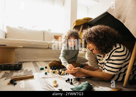 Eine fröhliche Familie genießt es, sich in einer selbstgemachten Deckenfestung zusammenzutun. Stockfoto