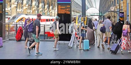 Gemischte Gruppe von Sommerpassagieren, die auf Bahnsteig 1 mit Koffer und Gepäck gehen, um an Bord des abfahrenden Zuges am Kings Cross London England UK zu gehen Stockfoto