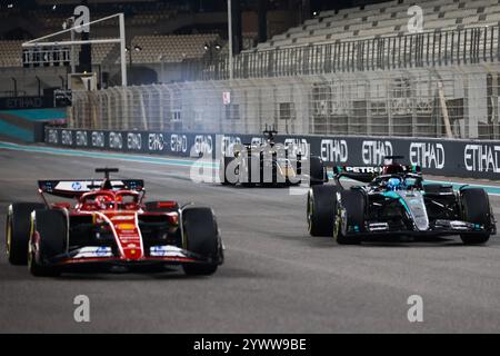 Abu Dhabi, Vereinigte Arabische Emirate. Dezember 2024. Die Autos von Charles Leclerc von Ferrari, George Russell von Mercedes und dem fiktiven Apex APXGP F1-Team im kommenden F1-Film und Joseph Kosinski sind auf einer Rennstrecke zu sehen, während sie eine Szene während der Formel-1-Tests auf dem Yas Marina Circuit am 10. Dezember 2024 in Abu Dhabi, Vereinigte Arabische Emirate, filmen. (Kreditbild: © Beata Zawrzel/ZUMA Press Wire) NUR REDAKTIONELLE VERWENDUNG! Nicht für kommerzielle ZWECKE! Stockfoto