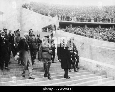 Reichskanzler Adolf Hitler (Mitte) begleitet von dem Präsidenten des Berliner Olympischen Organisationskomitees Theodor Lewald (3. V. l.) und dem Präsidenten des Internationalen Olympischen Komitees Henri de Baillet-Latour (1. V. l.), der das Olympiastadion verlässt. Archivfoto der Olympischen Sommerspiele 1936 in Berlin Stockfoto