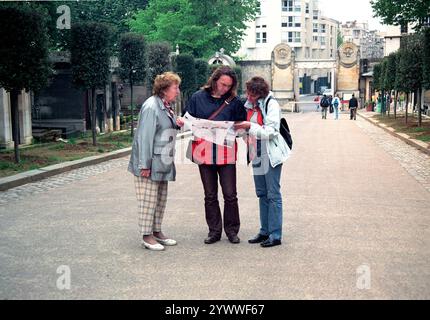 Drei Personen und eine Karte. Drei Personen studieren eine Karte auf Papier, während sie 2004 das Cementery Pere La Chaise in Paris, Frankreich, betreten. Paris Pere la Chaise Ile de France Frankreich Copyright: XGuidoxKoppesxPhotox Stockfoto