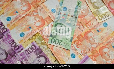 Philippinische Banknoten in Stückelungen von 20, 50, 100 und 200 Pesos auf einer flachen Oberfläche mit verschiedenen Helden und historischen Symbolen. Stockfoto