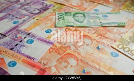 Philippinische Pesos-Banknoten sind verstreut und zeigen farbenfrohe Währungen der philippinen mit komplizierten Designs und verschiedenen Stückelungen. Stockfoto