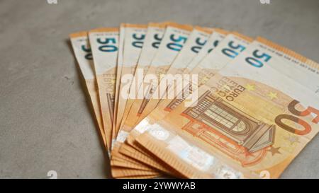 Euro-Banknoten, die auf einer konkreten Oberfläche aufgefächert wurden, heben die europäische Währung im finanziellen Kontext hervor Stockfoto