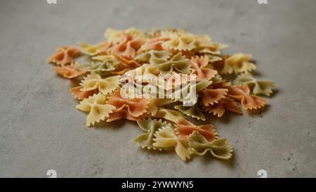 Farbenfrohe Pasta auf einer Betonoberfläche mit verschiedenen Formen und lebhaften Farbtönen der italienischen Küche und kulinarischen Zutaten. Stockfoto