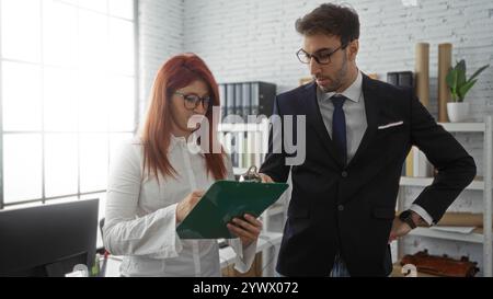 Hispanische Führungskräfte arbeiten in einem modernen Büroumfeld zusammen, prüfen Dokumente und diskutieren Geschäftsstrategien im Innenbereich. Stockfoto