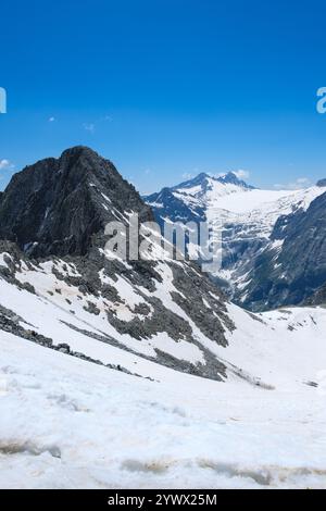 Majestätische schneebedeckte Gipfel erheben sich über das Tal in Vermiglio, Italien, und verkörpern eine atemberaubende Winterlandschaft. Der klare blaue Himmel trägt zur Ruhe bei Stockfoto