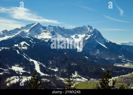 Schneebedeckte Gipfel prägen die Winterlandschaft in Garmisch-Partenkirchen. Der blaue Himmel steht im Kontrast zu den majestätischen Bergen und schafft eine Str. Stockfoto