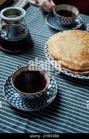 Eine gemütliche Frühstücksszene mit warmem Kaffee und flauschigen Pfannkuchen für ultimativen Komfort Stockfoto