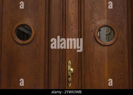 Wien, Österreich - 12. Mai 2019: Vorderansicht der Holztüren. Große Doppelscheunentür aus Vintage-Holz mit brauner Holzstruktur und Metallgriff, Nahaufnahme Stockfoto